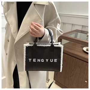 Close-up of brown plush tote bag with white faux fur trim and branded logo detail