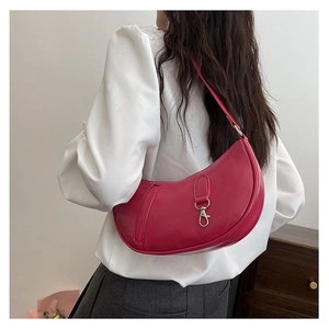 Detail of fuchsia crescent shoulder bag with silver hook buckle on white shirt