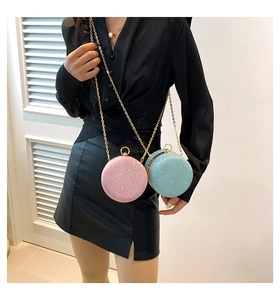 Dettaglio di borse da sera tonde glitter rosa e blu con tracolla a catena dorata