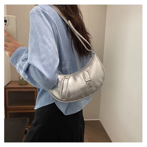Detail of silver crescent hobo bag with metallic crinkled texture and sleek shoulder strap