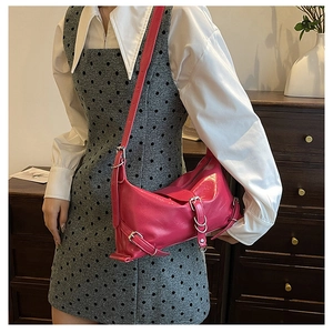 Detail of hot pink motorcycle bag with silver buckles and Y2K aesthetic style