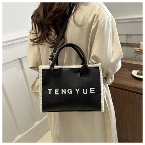 Black leather tote bag with white plush trim and TENGYUE logo held by a model