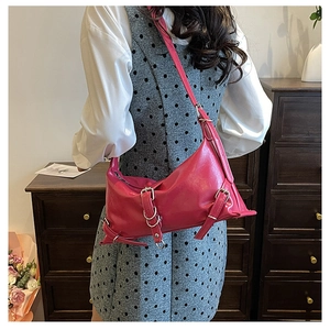 Detailed side view of a rose red PU shoulder bag with silver metallic belt decorations