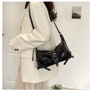 Detail of black pleated PU shoulder bag featuring silver buckle and vintage texture