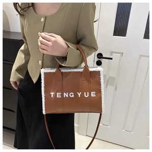 Detail of vintage brown leather tote bag with white plush trim and shoulder strap