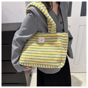 Detail of plush yellow and blue striped tote bag with soft faux fur texture on shoulder