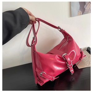 Detail of rose pink cracked patent leather shoulder bag with silver metal buckles