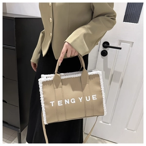 Close-up of khaki tote bag with plush white trim and branded TENGYUE lettering