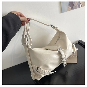 Detail of cream white pleated shoulder bag featuring silver hardware and buckle straps
