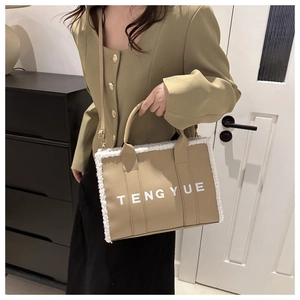 Close-up of khaki tote bag with white fleece trim and elegant golden metal hardware details