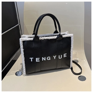 Close-up of black textured leather tote with white fleece trim and TENGYUE lettering