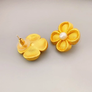 Gold four-leaf clover stud earrings with center pearl and textured woven metal petals