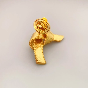 Elegante spilla a nodo in ottone placcato oro 18K con trama spazzolata e dettagli a corda