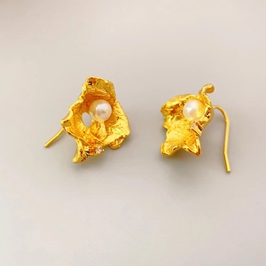 Vintage matte gold wrinkled leaf earrings with pearl and crystal detail on light grey background