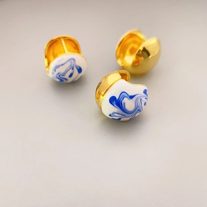 Golden hoop earrings with blue and white porcelain enamel finish and polished gold plating