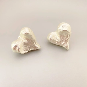 Vintage heart shaped stud earrings with silver textured finish and minimalist aesthetic