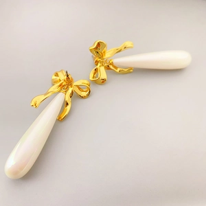 Eleganti orecchini a fiocco dorati con perle lunghe e accenti metallici lucidi per donna
