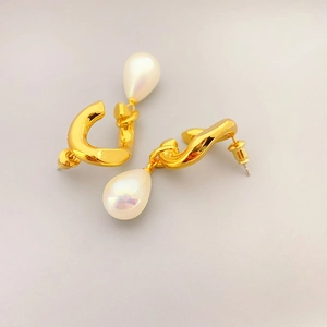 Boucles d'oreilles dorées avec design métallique ondulé et perles blanches en goutte