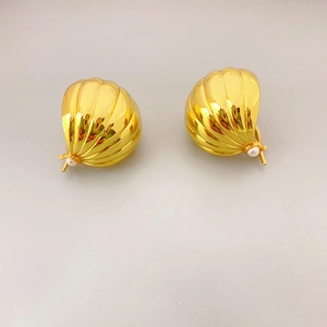 Boucles d'oreilles coquillage dorées 18K en laiton avec perle blanche sur fond beige clair