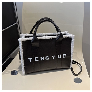 Detail of black leather tote bag with white fleece trim and TENGYUE printed logo