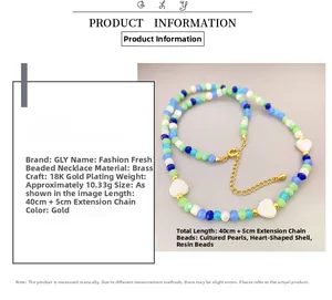 Detail of beaded necklace featuring 18K gold-plated brass, pearls, and shell hearts
