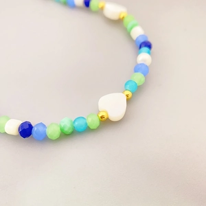 Colorful beaded necklace featuring heart shell pendant and cultured pearls with gold accents