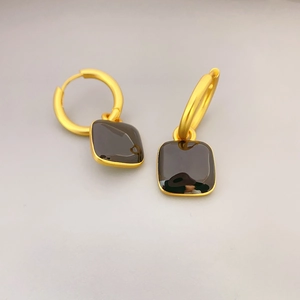 Boucles d'oreilles anneaux dorés avec pendentifs carrés en émail noir sur fond gris