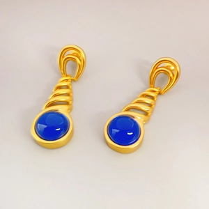 Detailed macro view of vintage gold twisted earrings with inset deep blue gemstones