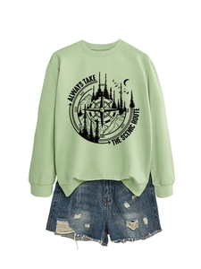 Detail of mint green sweatshirt with mountain print paired with ripped denim shorts