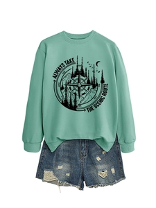 Detail of mint green mountain graphic sweatshirt paired with distressed denim shorts
