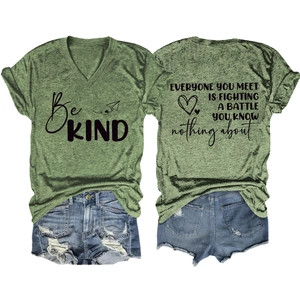 Flat lay of a green V-neck T-shirt with 'Be KIND' print and distressed denim shorts