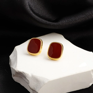 French vintage square burgundy stud earrings with gold metal frame on black silk background