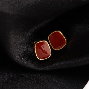 Vintage square burgundy enamel stud earrings with gold plating on black silk fabric