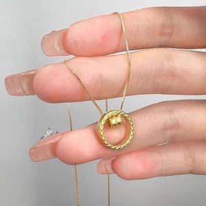Minimalist gold dual-ring necklace with textured rotating bead on cross chain