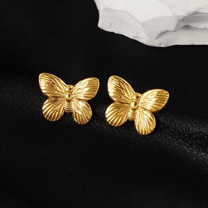 Elegant 18k gold plated butterfly stud earrings displayed on black silk and stone