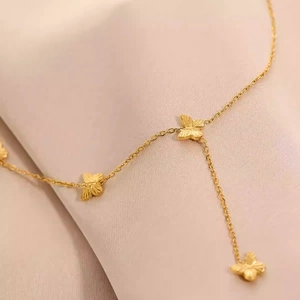 Collier en acier titane doré avec trois pendentifs papillons texturés sur soie rose