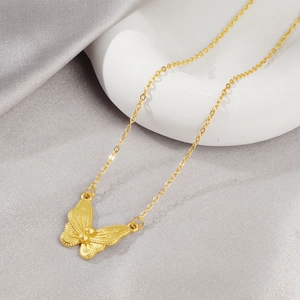 Elegante collana con ciondolo a farfalla dorata con trama vintage su fondo di seta