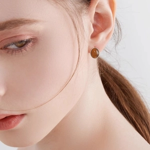 Retro-Ohrstecker mit braunem Bernstein und goldenem Seilrand im Vintage-Stil am Model