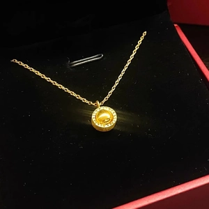Golden rotating globe necklace with cat-eye asteroid pendant on black velvet box