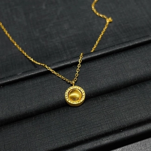 Minimalist gold spinning globe necklace with cat-eye planetary charm on black display