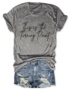 Detail of grey crewneck T-shirt with 'This is the Turning Point' text and denim shorts
