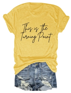 Macro detail of This is the Turning Point print on yellow cotton t-shirt and denim shorts