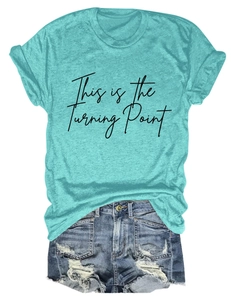 Flat lay of a turquoise round neck T-shirt with black text and ripped denim shorts