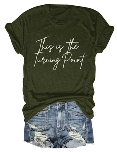 Detail of dark green t-shirt with This is the Turning Point print and ripped denim shorts