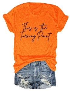 Detail of orange cotton t-shirt with 'This is the Turning Point' text and denim shorts