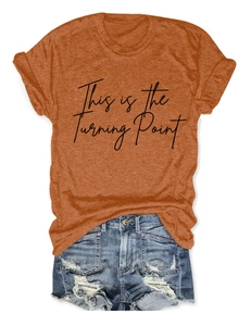 Detailed view of rust orange t-shirt with This is the Turning Point text and denim shorts