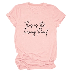 Close-up of pink round neck T-shirt featuring 'This is the Turning Point' text print