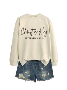Detail of cream sweatshirt with Christ is King text print and distressed denim shorts