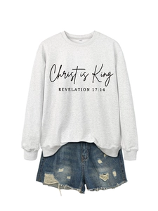 Detail of Christ is King grey sweatshirt with Revelation text and ripped denim shorts