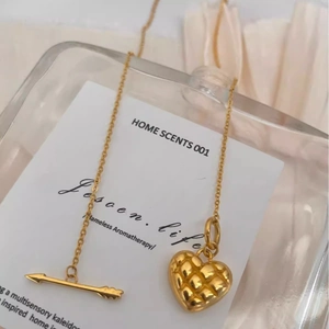 Elegante goldene Halskette mit gestepptem Herzanhänger und Pfeilverschluss auf Weiß